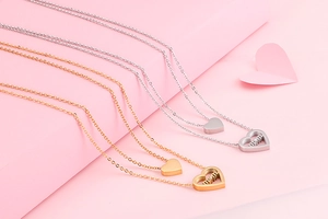 Detail of double-layer necklaces with gold and silver heart pendants engraved with MOM