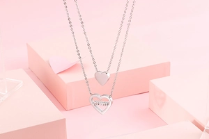 Detail of silver double-layer heart necklace with engraved mom lettering pendant