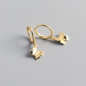 Close-up of golden butterfly drop earrings featuring small polished hoops and butterfly pendants
