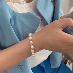Irregular freshwater pearl bracelet with gold spacers worn on a woman's wrist