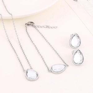 Détail de parure bijoux argentée avec cristaux en goutte incluant collier et bracelet