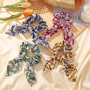 Set of four leopard print hair scrunchies with bunny ears on a decorative tray