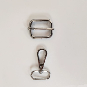 Détail d'une boucle de réglage argentée et d'un mousqueton pivotant pour bandoulière