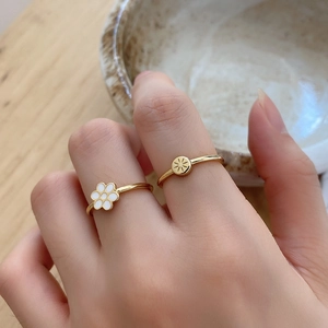Minimalist 925 silver rings set with white daisy and sunburst designs in gold finish