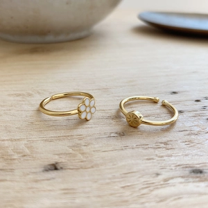 Minimalist 925 silver gold rings with white flower and star enamel designs on wood