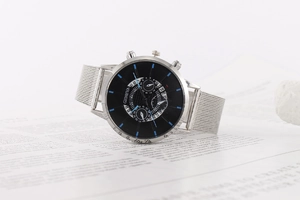 Detailed close-up of a silver mesh strap quartz watch with a black multi-dial calendar