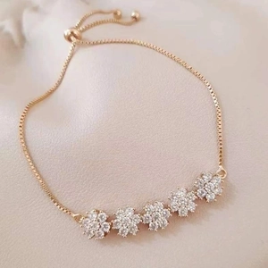 Adjustable gold box chain bracelet featuring five shimmering zircon flower charms