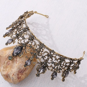 Detail of vintage bronze Baroque tiara with grey crystals on a natural stone base