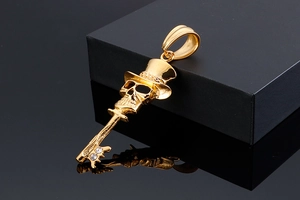 Macro view of gold skull key pendant featuring a top hat and sparkling rhinestones