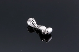 Macro shot of a polished silver boxing glove pendant with smooth metallic reflection