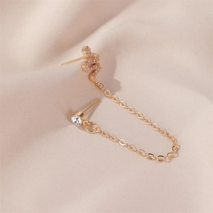 Detailed view of a gold snake-shaped ear cuff connected with a sparkling stone earring