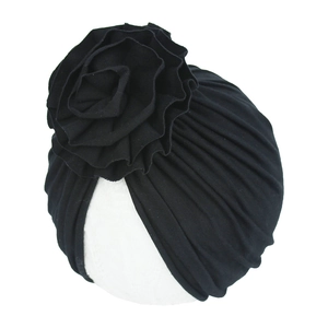 Détail du turban pour bébé en coton tricoté noir avec une grande fleur multicouche