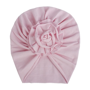 Détail du tissu tricoté rose clair et de la grande fleur en tissu sur le bonnet bébé