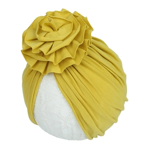 Détail du turban pour bébé en coton gingembre avec une grande fleur à volants superposés