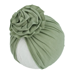 Détail du turban plissé vert gris pour bébé avec une grande fleur en tissu multicouche