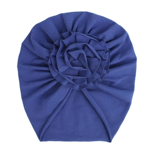 Détail d'un turban pour bébé bleu marine avec une grande fleur en tissu multicouche