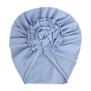 Détail du bonnet turban bébé bleu ciel en tricot avec une grande fleur 3D plissée décorative