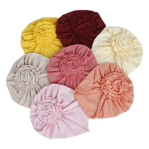 Détail à plat de bonnets bébé en coton tricoté avec fleurs multicouches en 7 couleurs