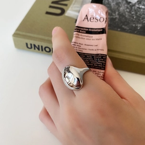 Irregular organic 925 sterling silver ring shown on hand with minimalist lifestyle backdrop