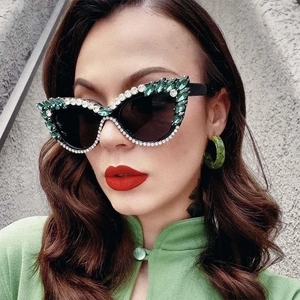 Fashionable green cat eye sunglasses with rhinestones and black lenses on model