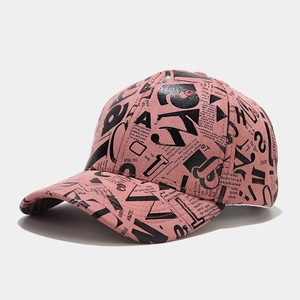 Detail shot of pink baseball cap with black letter graffiti print from a 45-degree angle