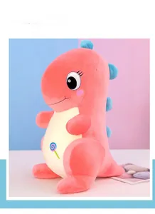 Detailed embroidery of a lollipop on a soft pink plush dinosaur toy's belly
