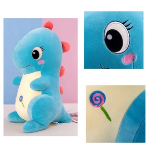 Detail of blue plush dinosaur with red fins and embroidered lollipop on its belly