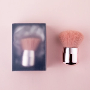 Detail of pink mushroom head powder brush with rose gold handle and its frosted packaging
