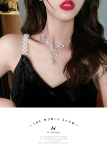 Detail of elegant rhinestone circle necklace with large white pearl on velvet dress