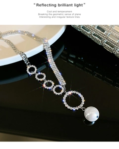 Detail of luxury rhinestone circles and white pearl pendant on a mixed chain necklace