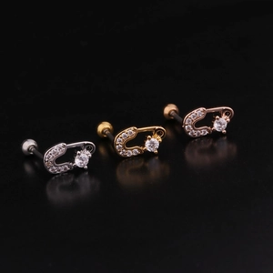 Close-up of lightning bolt piercing studs in silver gold and rose gold with zircon