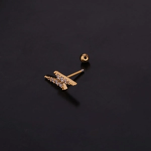 Macro shot of gold lightning bolt ear stud with clear zircon inlay and ball back