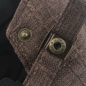 Close-up of vintage bronze metal buckle and dark brown tweed fabric on a retro beret hat