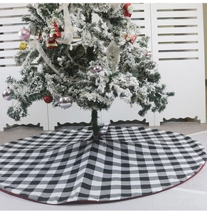 Détail du tapis de sapin de Noël à carreaux noirs et blancs autour du sapin décoré