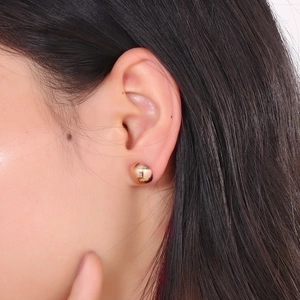 Macro view of 10mm rose gold dome stud earring worn on ear showing mirrored metal finish