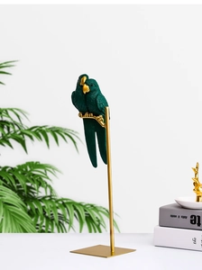 Detailed view of dark green resin parrot figurines with gold stands and feather texture