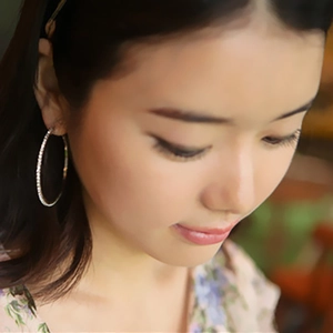 Detailed close-up of large silver hoop earrings featuring sparkling pave rhinestones on model
