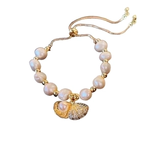 Elegant freshwater pearl bracelet with golden shell charm and adjustable slide clasp