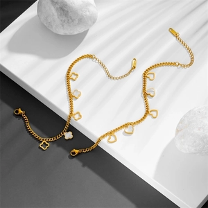 Detailed shot of golden stainless steel jewelry set with clover and heart clover pendants