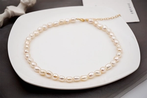 Dettaglio della collana di perle d'acqua dolce barocche su vassoio in ceramica
