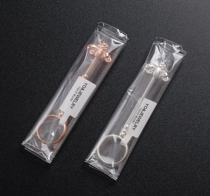 Detail of rose gold and silver bee cigarette ring holders in clear retail packaging