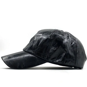 Side view of black glossy PU leather baseball hat with textured finish and curved brim