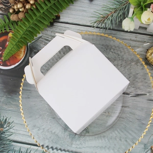 White kraft paper gift box with handle on glass plate with festive pine decorations