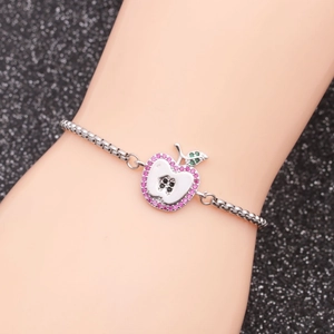 Silver stainless steel apple pendant bracelet with pink crystals on a black texture