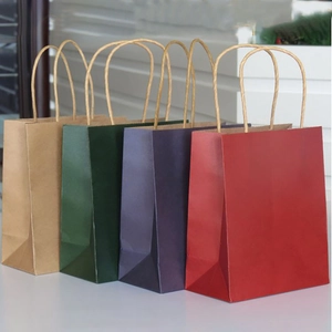 Row of colorful square gift bags in kraft, dark green, purple, and red with twisted handles