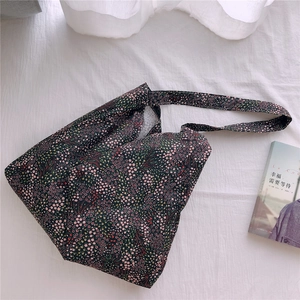 Detailed close-up of a black floral cotton tote bag with a soft aesthetic floral pattern