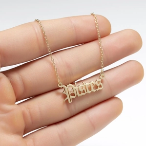 Detailed close-up of golden Pisces zodiac pendant necklace on a stainless steel chain