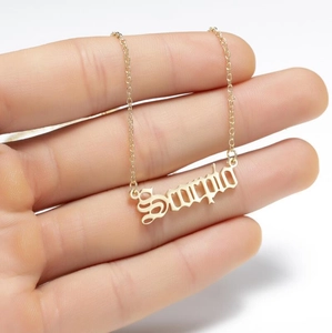 Close-up of golden Scorpio pendant necklace held in hand showing real size and shine
