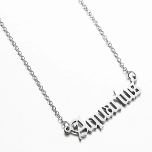 Macro shot of silver Aquarius zodiac letter pendant on a minimalist stainless steel chain