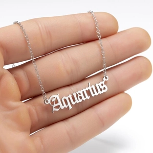 Detailed view of silver Aquarius zodiac letter pendant on a delicate stainless steel chain